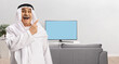 © Ljupco Smokovski - Happy mature arab man pointing at a tv screen