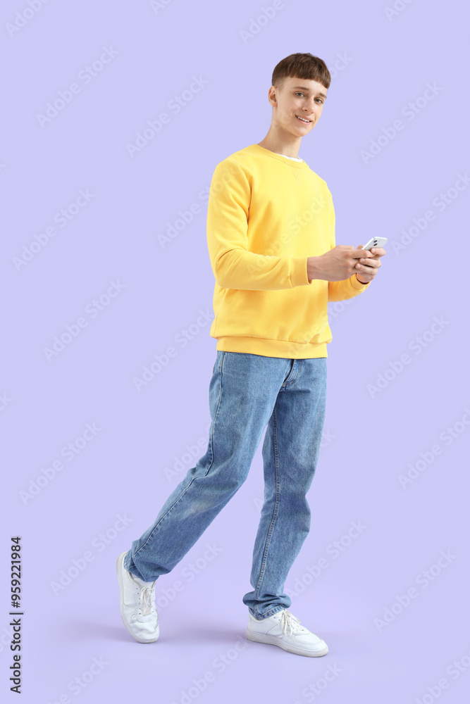 Young man using mobile phone on lilac background