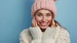 © Marco - beautiful woman smiling at camera in woolen coat and pink hat on blue background