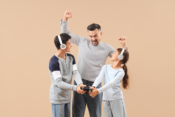 Wall Mural - Father with his children in headphones playing video game on beige background