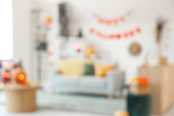 Sticker - Blurred view of light living room decorated for Halloween with sofa, table and shelf unit