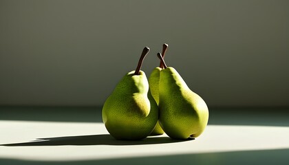 A pair of green pears are placed on a flat surface with a simple background that highlights the natural color and shape of the pears.