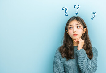 Poster - A young Japanese woman in a blue blouse is thinking with a question mark on a white background