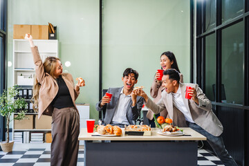 Asian office colleagues and friends enjoy a daytime BBQ with pizza and beer, celebrating Halloween and cheering for their favorite soccer team, creating a lively atmosphere filled with joy.