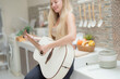 © ultramansk - A musician woman plays an acoustic guitar in a bright kitchen, combining the themes of domestic life and artistic expression, reflecting a relaxed lifestyle focused on creativity and comfort.