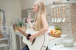 © ultramansk - A musician woman plays an acoustic guitar in a bright kitchen, combining the themes of domestic life and artistic expression, reflecting a relaxed lifestyle focused on creativity and comfort.