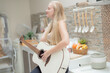© ultramansk - A musician woman plays an acoustic guitar in a bright kitchen, combining the themes of domestic life and artistic expression, reflecting a relaxed lifestyle focused on creativity and comfort.