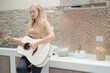 © ultramansk - A musician woman plays an acoustic guitar in a bright kitchen, combining the themes of domestic life and artistic expression, reflecting a relaxed lifestyle focused on creativity and comfort.