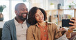 © WesLens/peopleimages.com - Mature couple, selfie and smile on sofa in home with hug, bonding and love with photography in lounge. Man, woman and happy on couch for profile picture, memory or post on social network in apartment