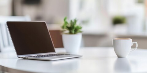 Blurred modern home office interior with laptop and coffee cup on a white table, close-up panoramic view, ideal for web design or graphic illustration backgrounds.