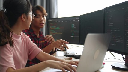 Slow motion back end software developer engineer for computer programming working together on debugging writing computing code, solving complex algorithms display on monitor in office. Burgeoning