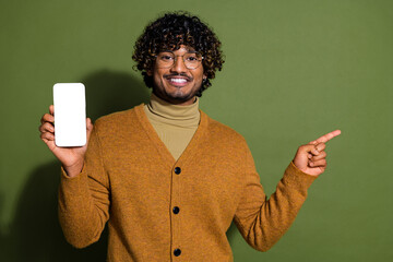 Poster - Photo of handsome young guy hold device white screen point empty space dressed stylish brown garment isolated on khaki color background