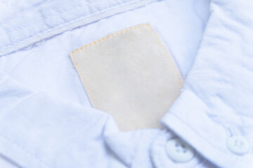 Close-up view of blank clothing labels on white shirt fabric