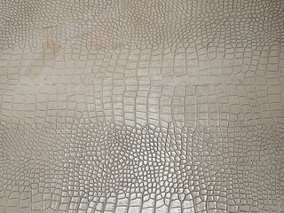 Close up photo of snake scale skin crafted and printed on a genuine leather sheet on table top.