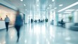 © adri - Blurred motion of people walking in a modern office building hallway.