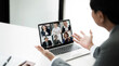 © NAMPIX - Man sits at a table in front of an open laptop, actively participating in a video conference.