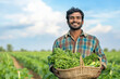 © Niks Ads - happy indian farmer holding a basket of freshly harvested vegetables