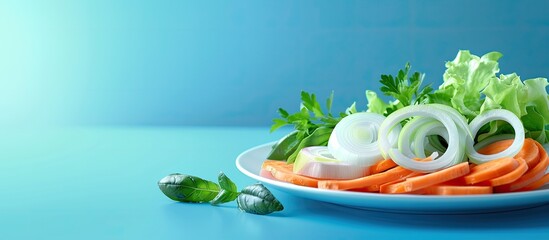 Sticker - Fresh raw sliced vegetables including onions and carrots arranged on a plate with a blue background Copy space