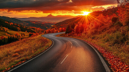 A winding black road cuts through a vibrant autumn landscape.  The setting sun paints the mountains in shades of red, orange, and yellow. It's a beautiful scene, typical of Germany in the fall.