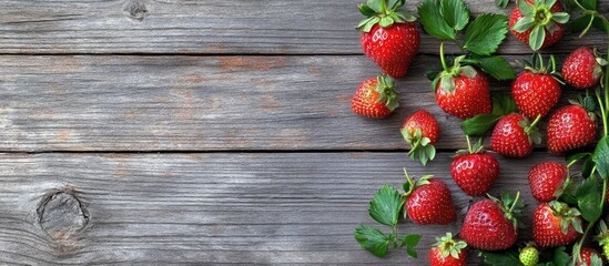 Wall Mural - Fresh garden strawberries on a weathered wooden backdrop top view copy space