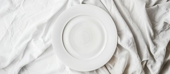 Poster - Top view of an empty round white plate on a colored background tablecloth suitable for food Blank dish on a napkin with room for your design. with copy space image. Place for adding text or design