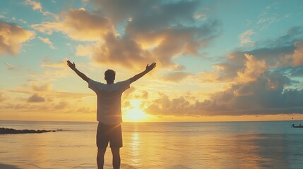 A man stands on the beach, his arms raised high in the air, as he enjoys the beauty of the sunset. He is filled with joy and happiness. In another moment, a traveler stands with his hands up