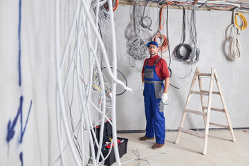 Wall Mural - Electrician working on a wire system on a construction site.