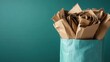 © svastix - An image showing crumpled cardboard pieces stuffed inside a teal bag. This representation emphasizes waste management and recycling in everyday life.