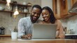 © Sandu - Couple Using Laptop in Kitchen
