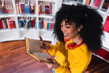 Happy reader reading a paper book in a library