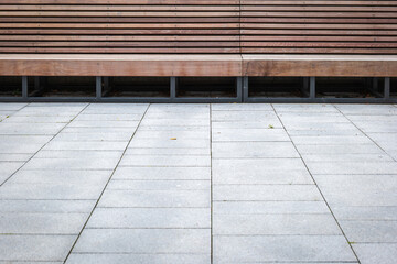 Modern wide wooden bench in city on cloudy day