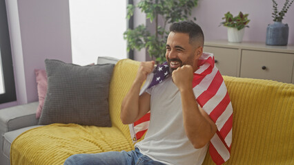 Wall Mural - Hispanic man smiling holding american flag in a modern living room