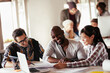 © Geber86 - Designer team collaborating on project with blueprints in office