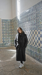 Smiling woman in glasses posing in historic topkapi palace with intricate turkish tiles in istanbul.