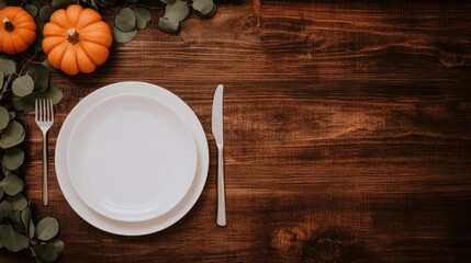 This elegant autumnal wedding table setting showcases vibrant pumpkins, white plates, and green eucalyptus garlands on a stylish gold tabletop, offering a minimalist aesthetic