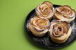 © New Africa - Freshly baked apple roses on green background, closeup