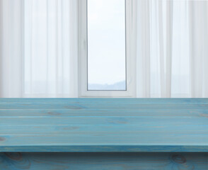 Canvas Print - Empty light blue wooden table near window with curtains. Space for design