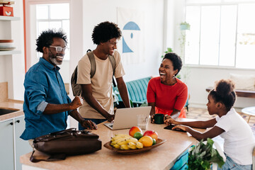 Family of four laughing and enjoying their morning routine at home