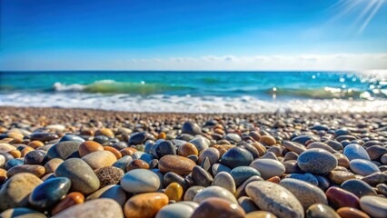 Close up view of pebbles and stone rocks on a beach with blue ocean in the background