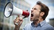 © makentosha - Handsome man shouting through megaphone angry and mad screaming frustrated and furious, shouting with anger. rage and aggressive concept.