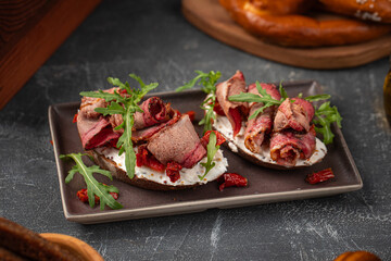 Two portions of bruschetta appetizers with pastrami