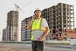 © Studio Peace - Architect is talking on the phone at a construction site in a protective helmet and vest.