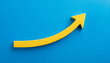 © hardvicore - Yellow wooden arrow pointing upwards on blue background. Business and market growth concept