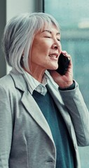 Canvas Print - Business, mature woman and phone call in office for project management, communication and deal negotiation. Asian professional, CEO and smartphone for contact, mobile chat and networking at window