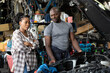 © offsuperphoto - customer and mechanic looking at car engine. they're feeling bad because a car is trouble in automobile repair shop