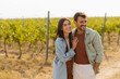 © BGStock72 - Couple strolls hand in hand along a sunlit path amidst lush vineyards during a warm afternoon
