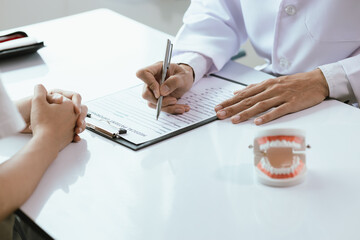 In a dental clinic, orthodontists and nurses work together to examine and treat patients' oral health. They discuss dental hygiene, repairs, and care while ensuring that the visit is comfortable.