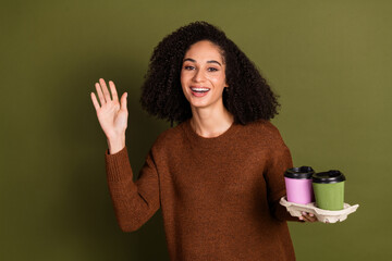 Wall Mural - Photo of nice young woman coffee arm wave hi wear pullover isolated on khaki color background