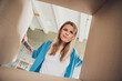 © deagreez - Photo of customer young blonde hair funny girl in blue shirt doubtful confused unpacking parcel delivery goods check whats inside box