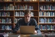 © Nognapas - Handsome Male Student With Laptop no logo and Books Working in a High School Library